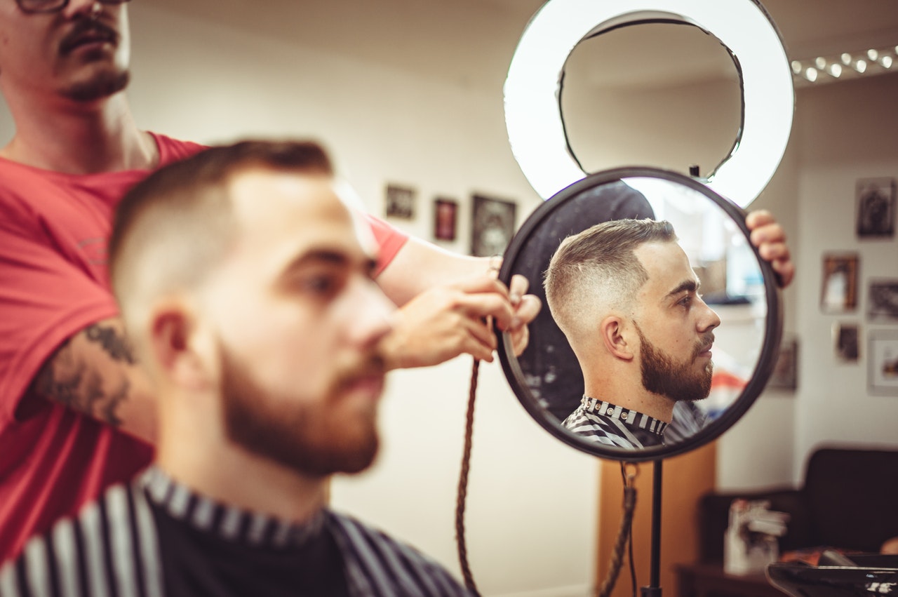Man seeing his haircut in the Barber's mirror.